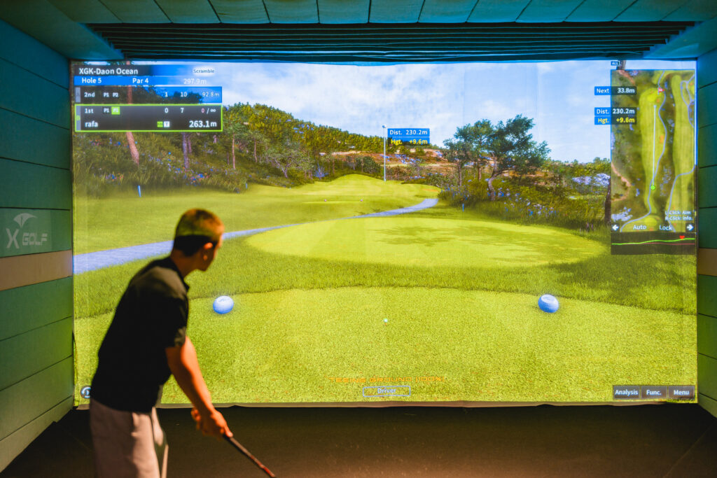 Boy lining up putt on X-Golf simulator with green grid display