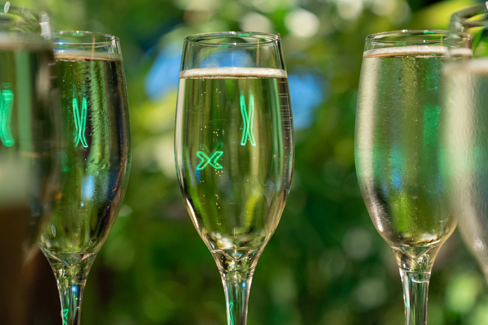 Sparkling champagne glasses at X-Golf Morley with green reflections