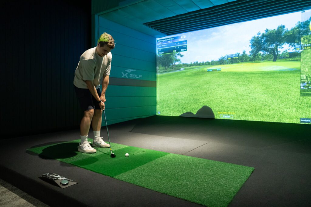 Man practicing swing in simulator at X-Golf Morley