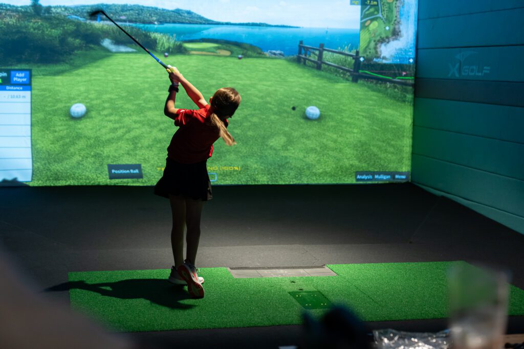 Girl playing virtual golf at X-Golf Morley venue