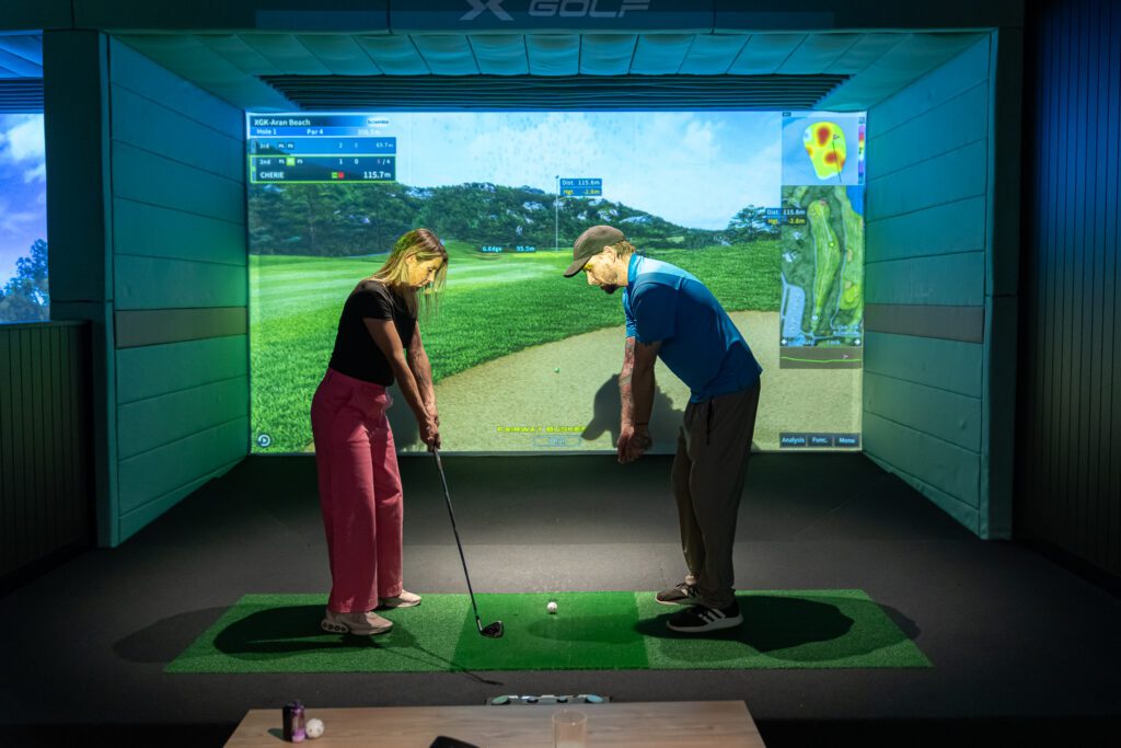 Golf coaching session inside simulator bay at X-Golf Morley