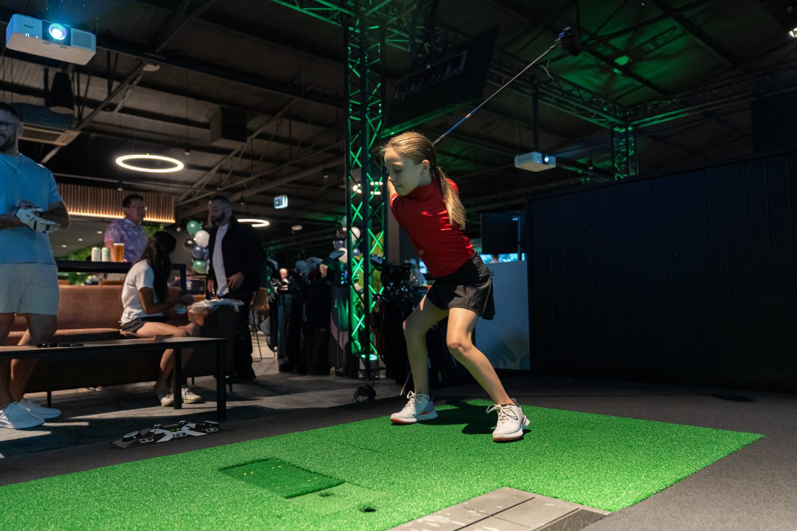 Girl Playing on The Golf Simulator at X-Golf Venue