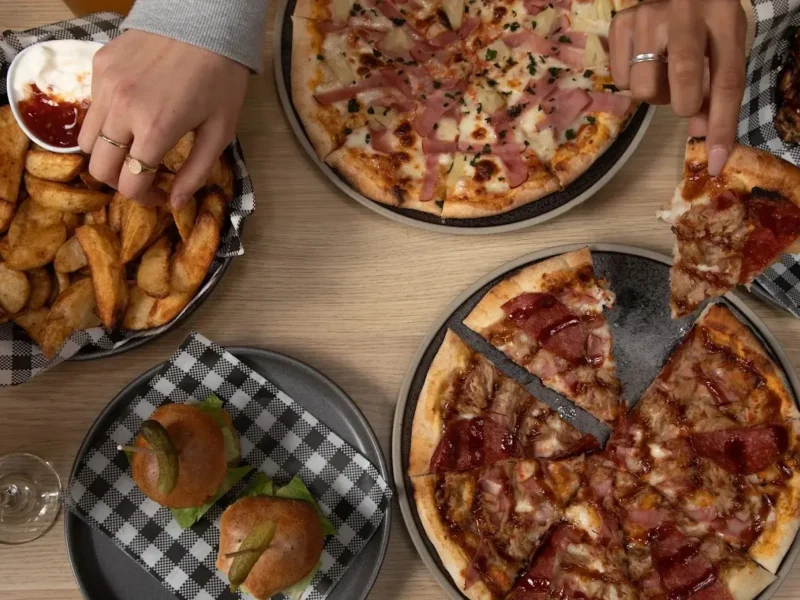 Pizza and sides served during a family indoor golf session at X-Golf