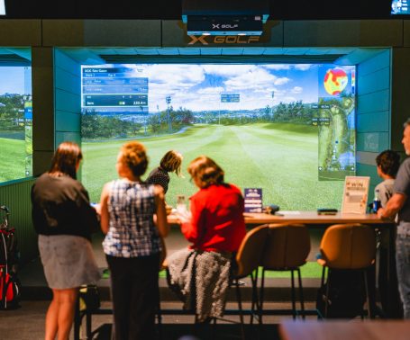 Guest taking golf shot at X-Golf Surrey Hills simulator
